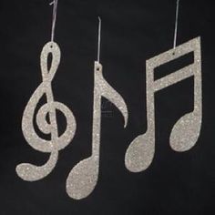 three silver musical notes hanging from strings