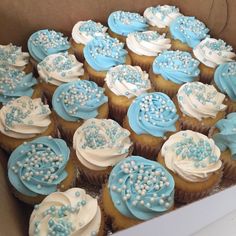 a box filled with blue and white cupcakes