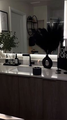 a bathroom vanity with a mirror, sink and various items on the counter top in front of it