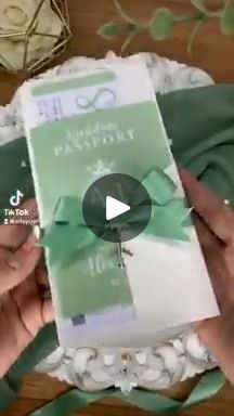 two hands are holding a package with green ribbon on it, and another person is opening the package in front of them