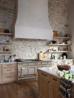 a kitchen with stone walls and wooden floors