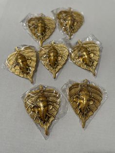 six gold lion head magnets in plastic bags