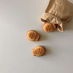 three cookies with faces on them sitting next to a paper bag