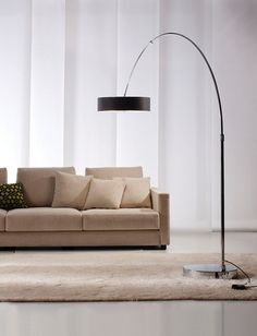 a living room scene with focus on the couch and floor lamp in the foreground