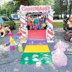 an entrance to a candy shop with balloons and streamers on the ground next to it