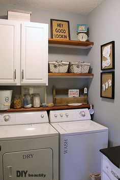 a washer and dryer in a laundry room with shelves on the wall above them