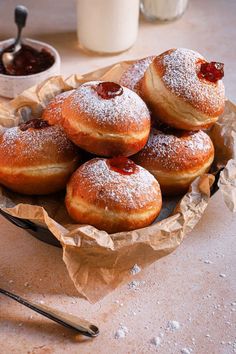 powdered sugar covered doughnuts in a bowl on a table