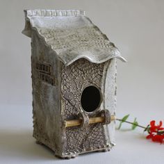 a bird house with a stick sticking out of it's hole in the side