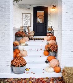 pumpkins and gourds are sitting on the steps