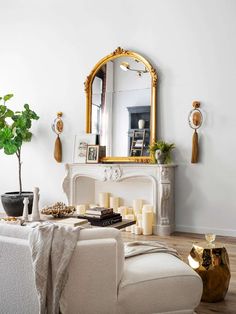 a living room filled with furniture and a large mirror on the wall over a fire place