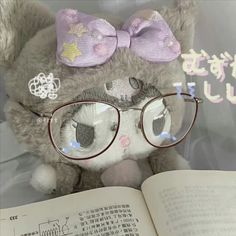 a teddy bear wearing glasses reading a book