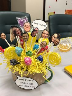 an arrangement of lollipops in a coffee cup with faces on the sides