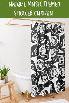 a shower curtain with black and white music themed design on it, next to a bathtub