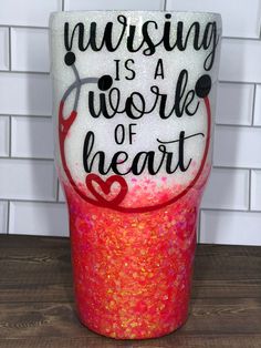 a cup with the words nursing is a work of heart painted on it's side