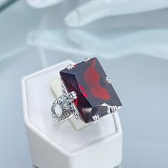 Huge Garnet CZ Sterling Silver Ring 6-Prong Design#D104 It's easy to fall head over heels for our beautiful 6-Prong Ring D104! This is a show-stopping 1930s vintage-inspired piece crafted in sterling silver. The sophisticated art deco design features a gorgeous rectangle-cut gem that is a whopping 20mm by 15mm, creating a truly eye-catching and dazzling look. As a finishing touch, the inside of this ring is monogrammed with "925" for sterling silver. With its ornate filigree details and 6 sturdy Sophisticated Art, Prong Ring, Deco Ring, Style Aesthetic, Cubic Zirconia Rings, Silver Art, Cz Ring, Engraved Items, Garnet Rings