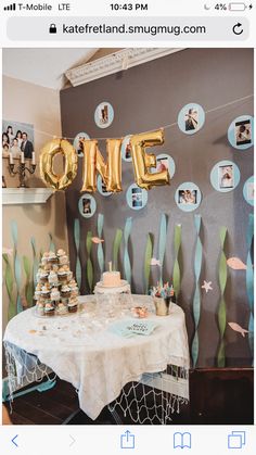 the table is set up for a one year old birthday party with balloons and confetti