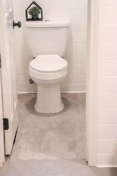 a white toilet sitting in a bathroom next to a doorway