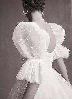 black and white photo of woman in dress with pearls on her head, back view