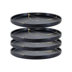 four black plates stacked on top of each other, with gold lines painted on them