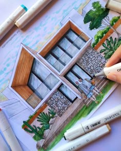 someone is drawing a house with colored pencils