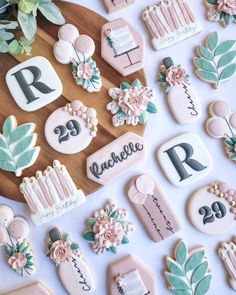 decorated cookies are arranged on a table with flowers and numbers in the shape of letters