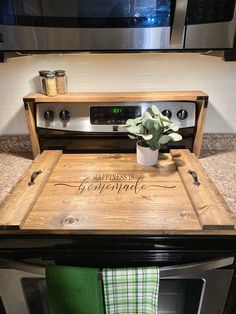 a potted plant sitting on top of a wooden tray in front of an oven