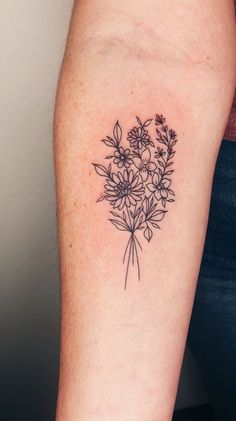 a black and white flower tattoo on the right arm, with small flowers in it