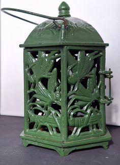 a green birdcage is sitting on the floor