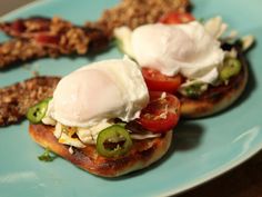 two open faced sandwiches with tomatoes, cucumbers and sour cream on them sitting on a blue plate