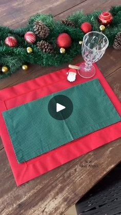 a table with a red place mat and green placemat on it next to christmas decorations