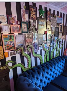 a blue couch sitting next to a wall covered in pictures