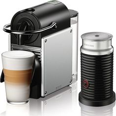 an espresso machine with two cups next to it and another coffee cup on the side