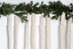 christmas garland hanging on the wall with pine cones