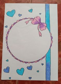 a piece of paper with hearts and a ribbon around it on a tile floor next to a wall