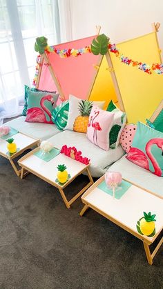 the couch is decorated with colorful pillows and pineapples, flamingos, and other tropical items