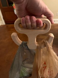 a person holding onto a wooden handle with plastic bags in it