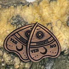 These ouija board planchette piece wood earrings are perfect for any mystic, macabre, spirit board, ghost, or mystery lover in your life. Show off your paranormal side with these beautiful planchette earrings. Laser engraved on a walnut finish they measure approx. 1.5 inches tall and 1.4 inches wide. They hang on gold colored hardware. These earrings are lightweight and compliment any outfit. These are laser engraved and hand assembled in my studio in North Carolina. *Photos are representative o Ouija Board Planchette, Witchy Earrings, Hello Goodbye, Personalized Piggy Bank, Funny Ornaments, Spirit Board, Ouija Board, Wooden Earrings, Wood Earrings