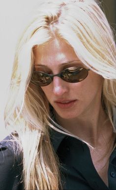 a woman with long blonde hair wearing sunglasses