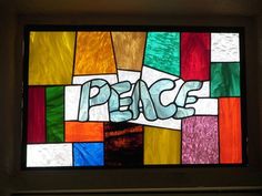 a stained glass window with the word peace written on it