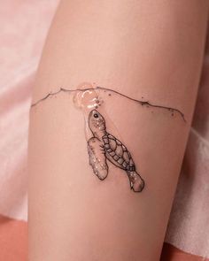 a small turtle tattoo on the side of a woman's leg