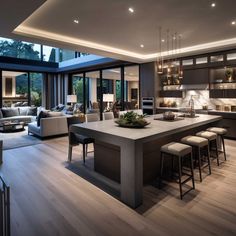 a large open kitchen and living room with lots of windows on the side of it