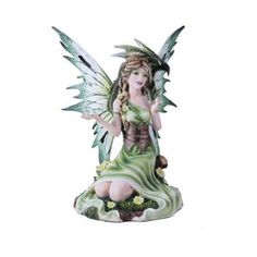 a green fairy figurine sitting on top of a rock