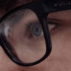 a close up of a person's eye with glasses on top of their head