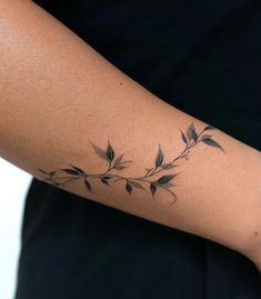 a woman's arm with a branch tattoo on it