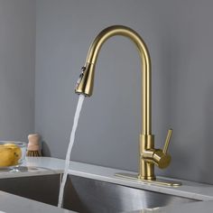 a faucet running water in a kitchen sink with lemons on the counter