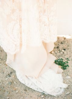 a bride's wedding dress and shoes on the ground