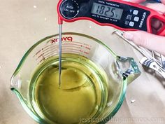 a measuring cup with liquid in it and a digital thermometer next to it