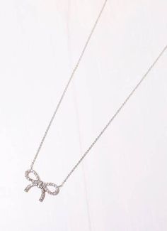 This delicate necklace features a CZ lined bow accent. Wear alone or layered with other necklaces for a fuller look. Dimensions: 16" long 2" extender Bow Dimensions: 1" wide by 0.6" long Chic Silver Jewelry With Bow Tie Detail, Adjustable Silver Necklace With Bow, Bow Necklace, Full Look, Delicate Necklace, Necklace Silver, Silver Necklaces, Necklaces, Silver