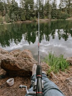 someone is sitting on the ground with their fishing rod