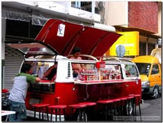 an old vw bus is parked in front of a building with its hood open